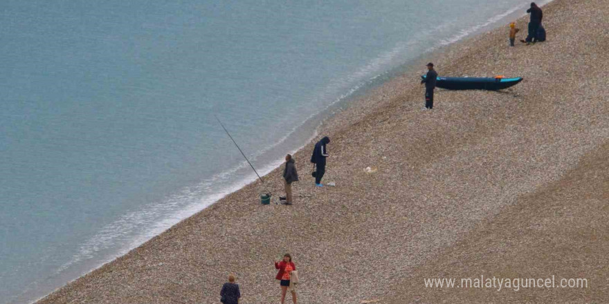 Antalya’da yağmura rağmen şemsiye altında deniz keyfi