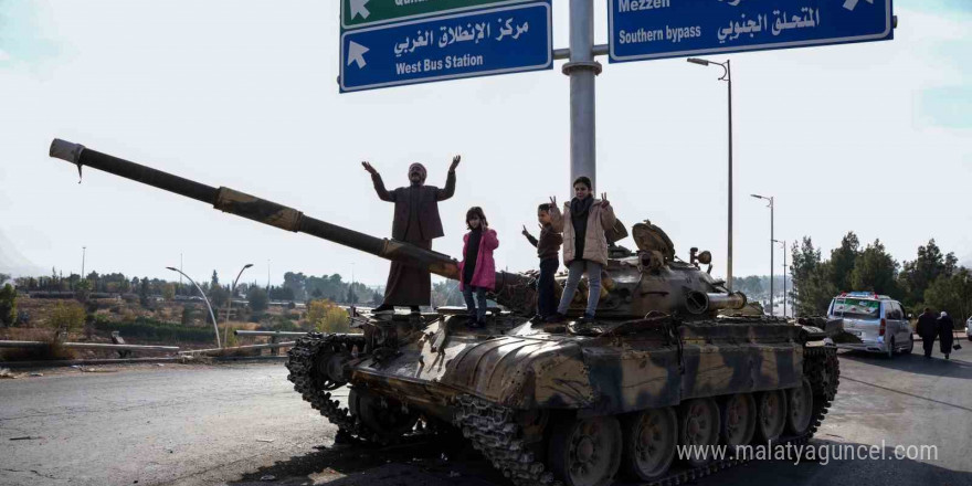 Suriyelilerden Esad rejiminden geriye kalan tankların üzerinde “zafer” pozu